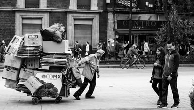一名男子拖着装有纸板箱的货车